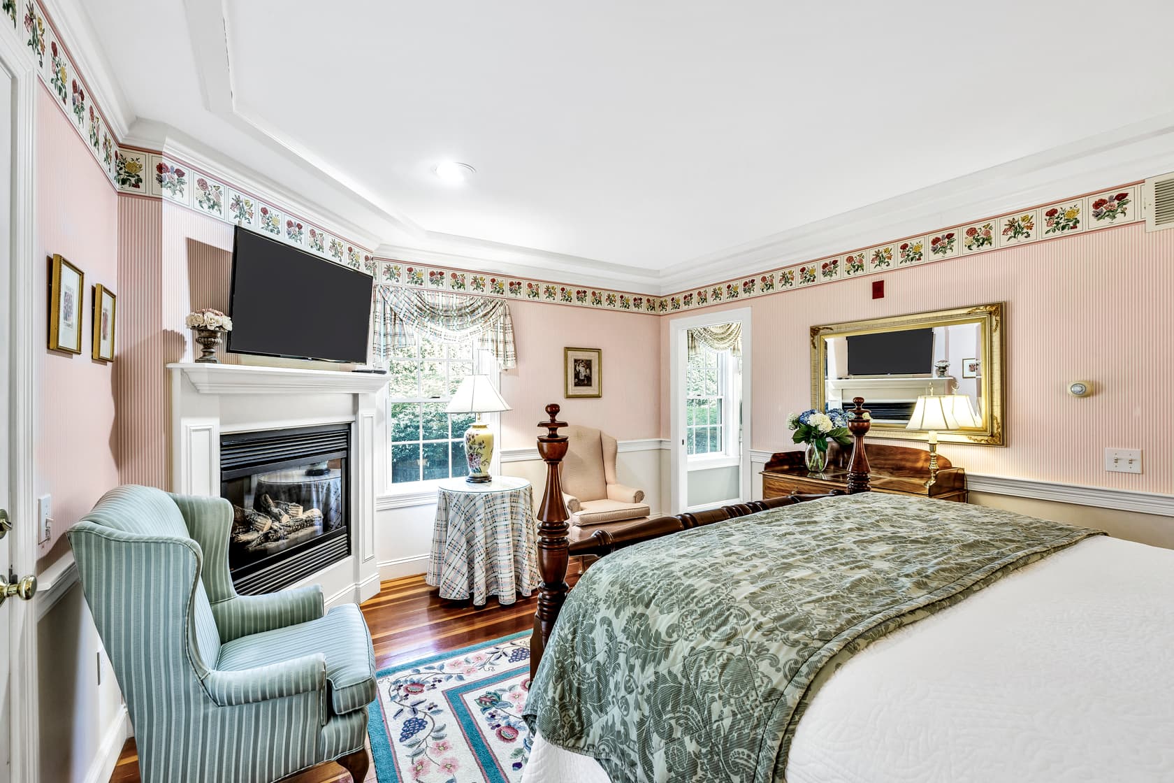 bathroom with sea foam green walls, sink with mirror above, tooth brush holder, glasses, toiletries, tissue paper above toilet seat and shower curtain