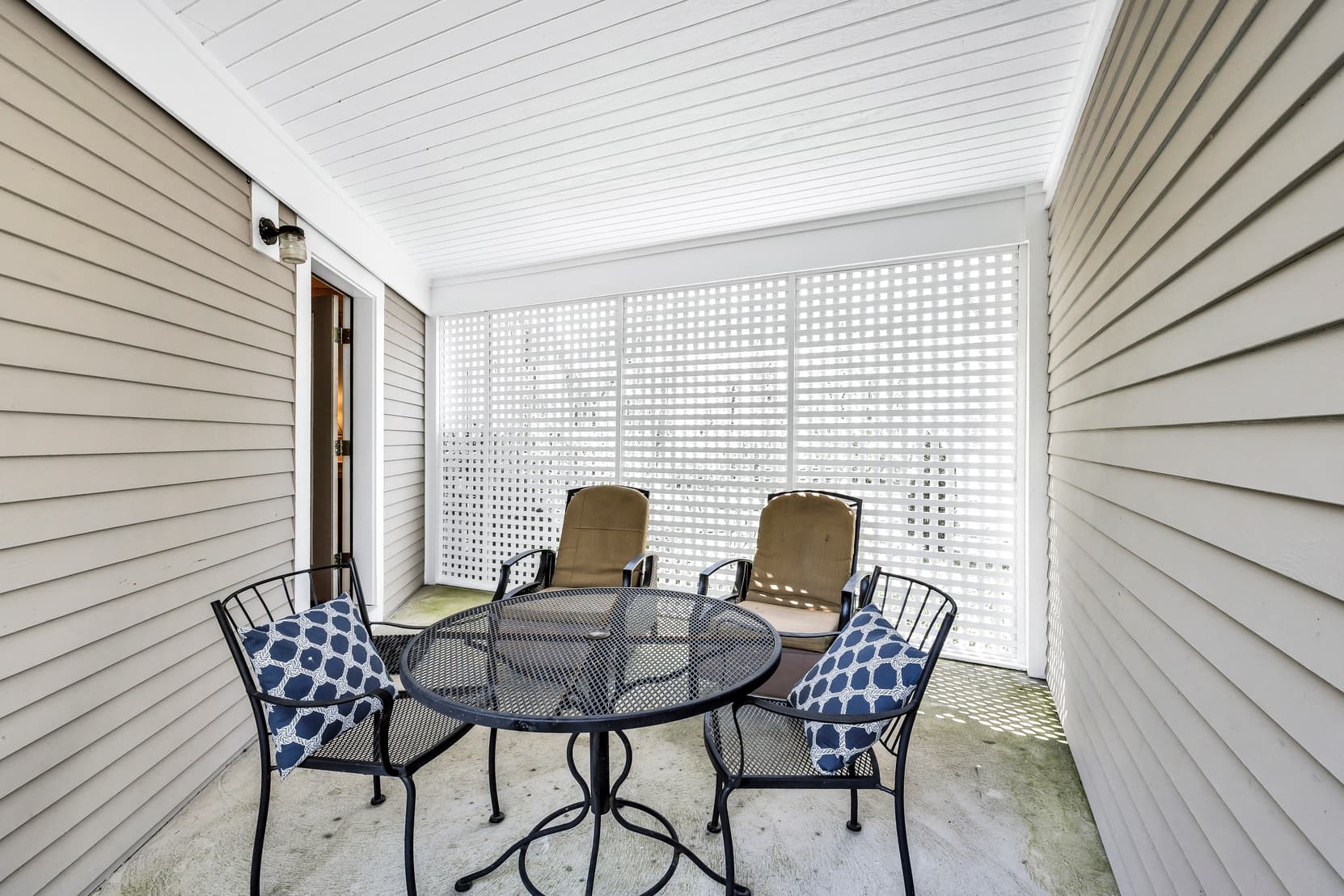 covered patio with table, chairs and loungers