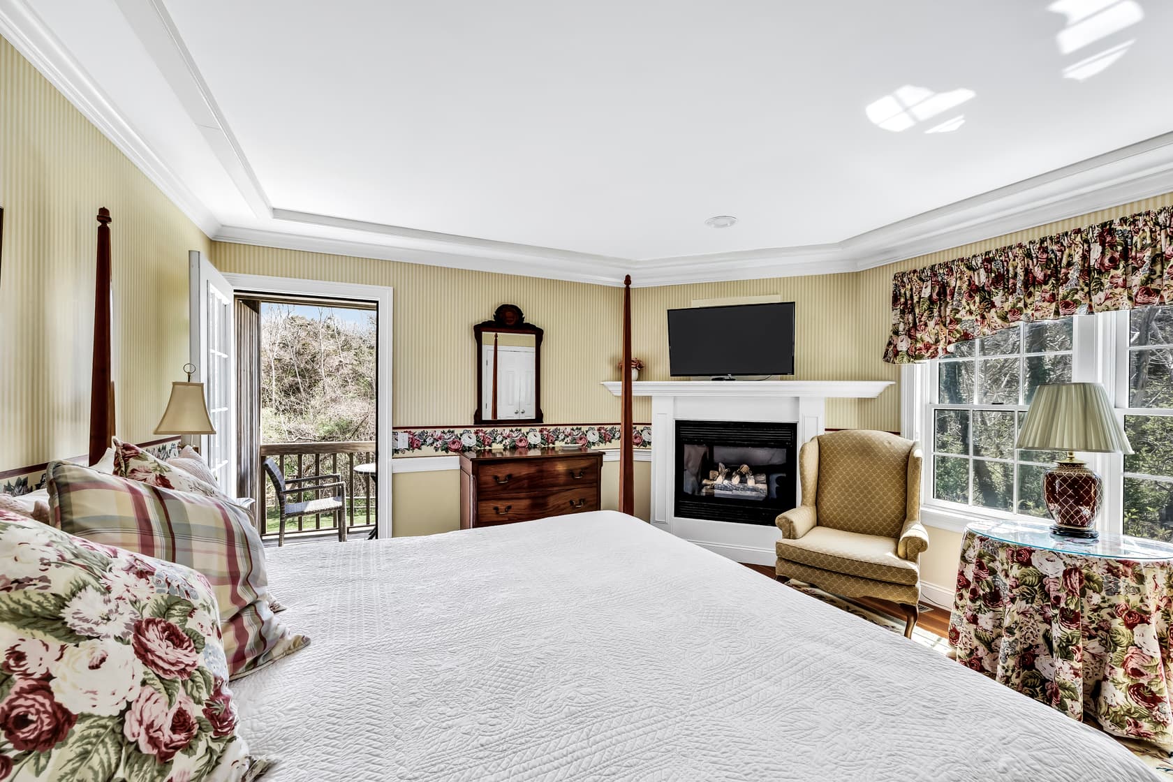 bathroom with spa tub, separate shower, vanity with green top, mirror and scones above