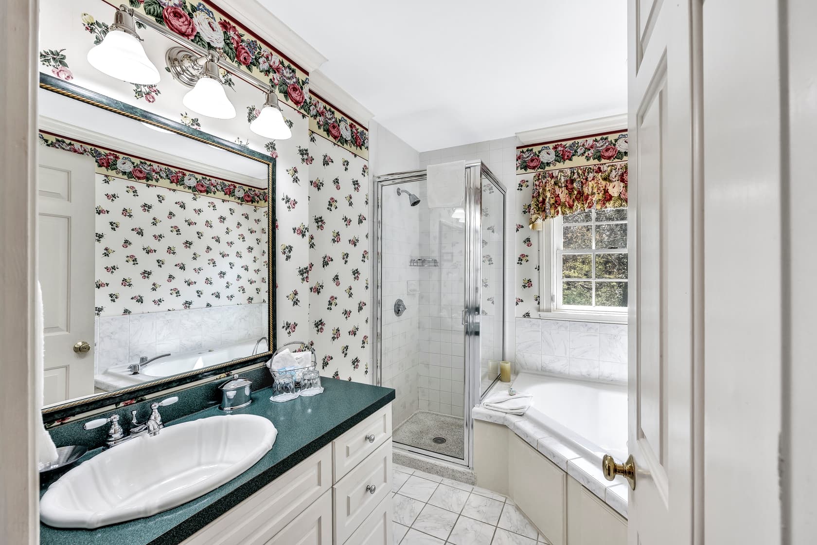 closer view of 4 poster king bed, fireplace, flatscreen TV and sitting area