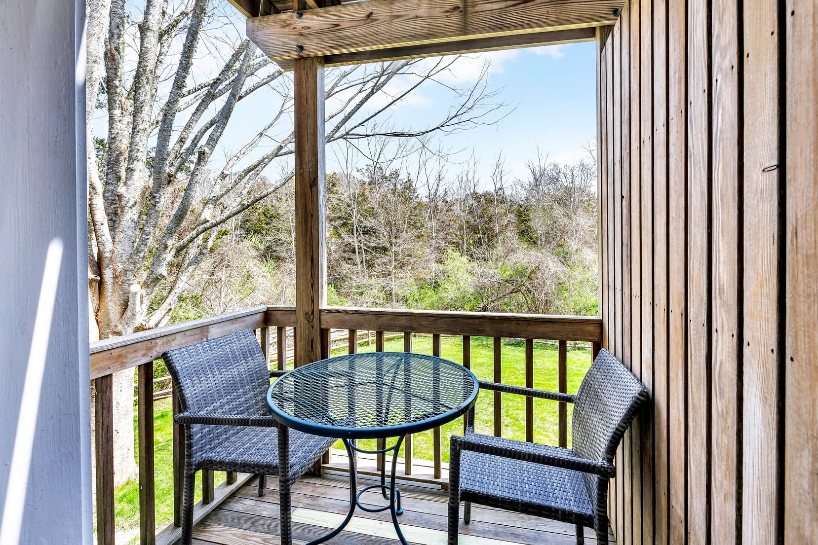 View of room with balcony door open, dresser with mirror above, fireplace, TV, sitting area by windw