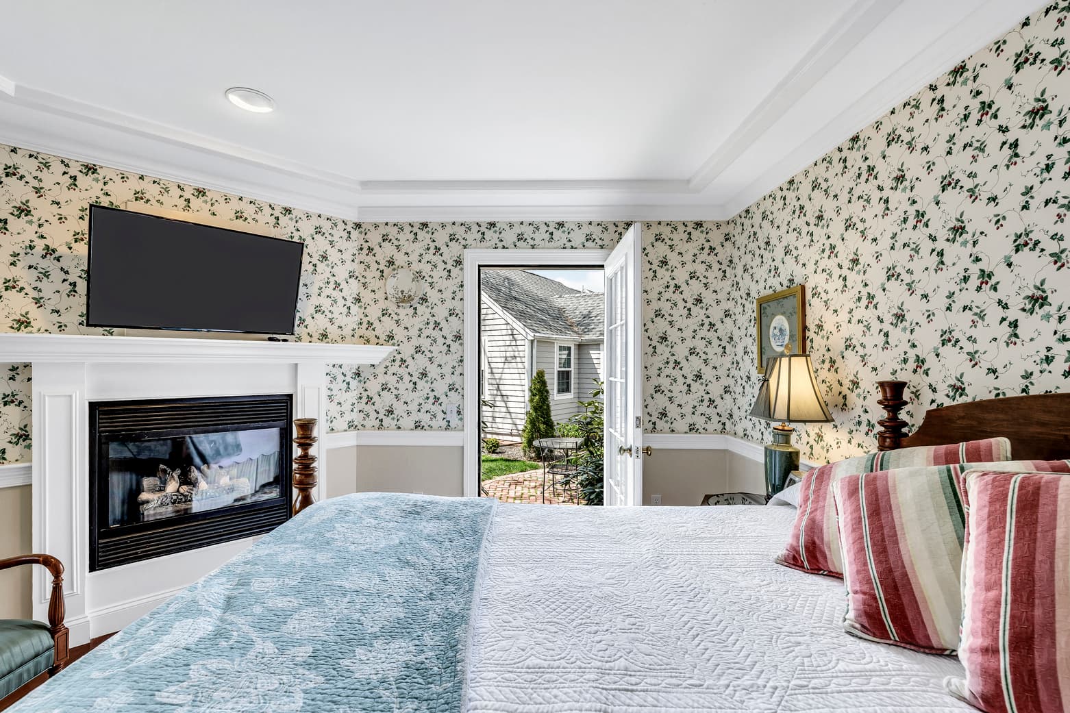 private bath with shower/tub combo, toilet and sink with mirror and light scones above, seafoam green color wall