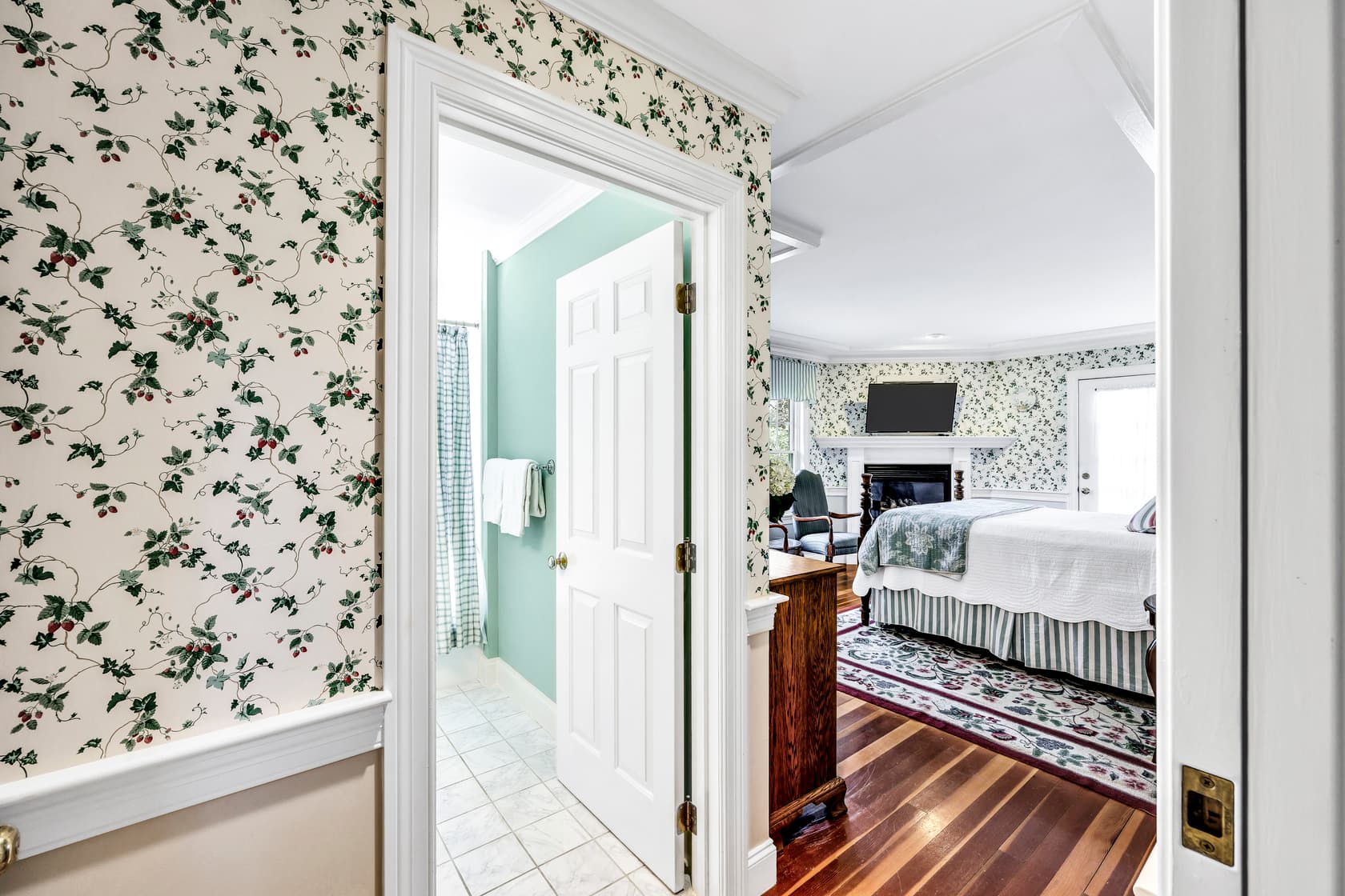 view from entrance of bathroom and Queen bed, wood floors, dresser