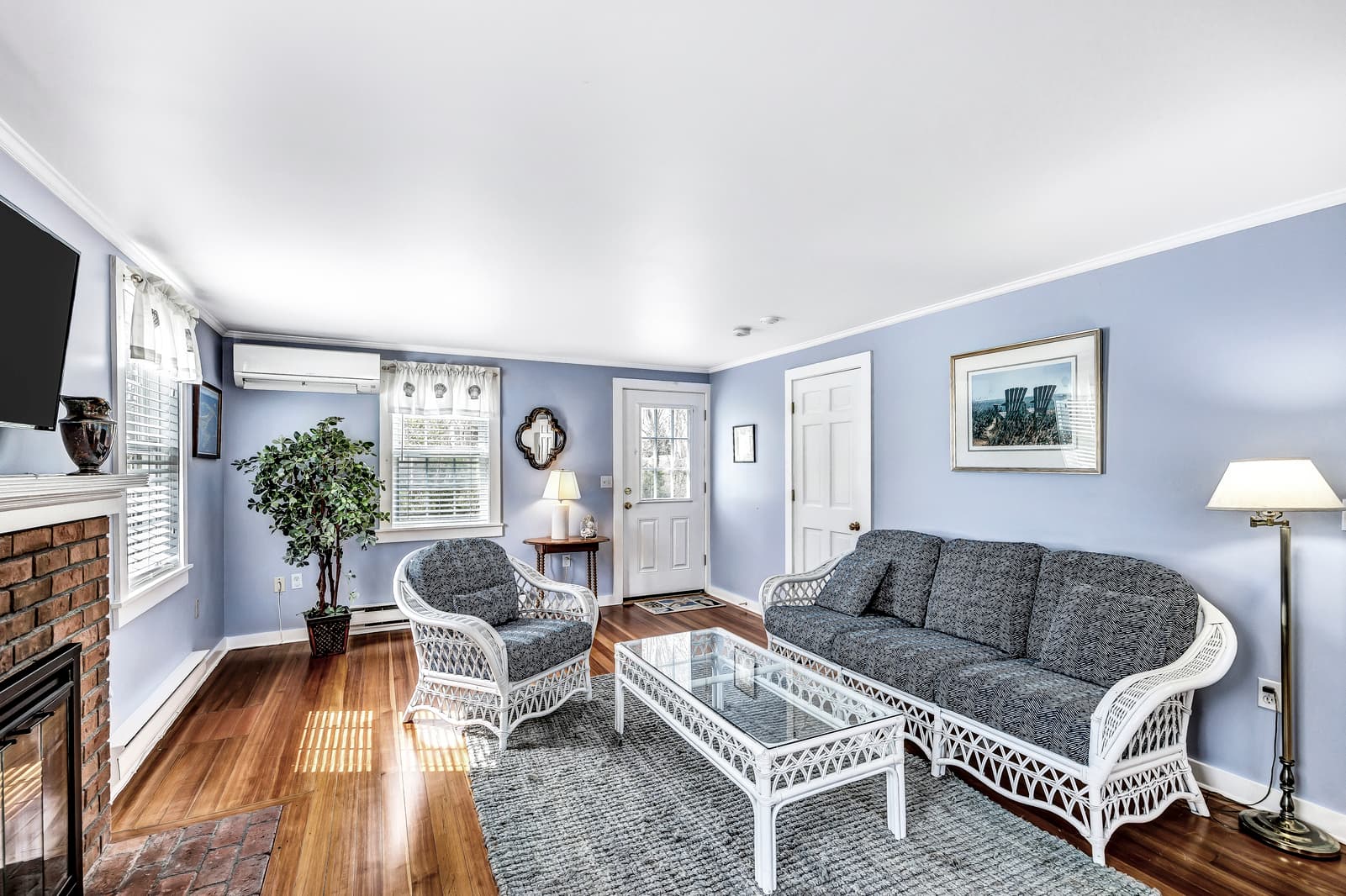A compact kitchenette with dark wood cabinets, a stainless steel sink, a microwave, and a small white refrigerator.