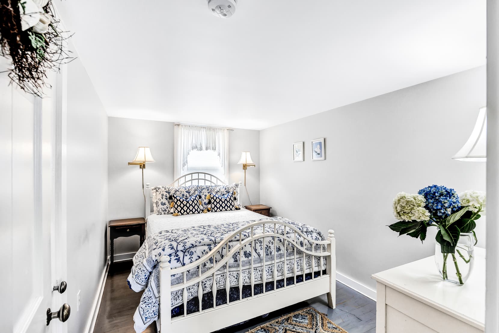 seating area with rattan furniture and matching table, standing lamp, light blue walls, next to large window