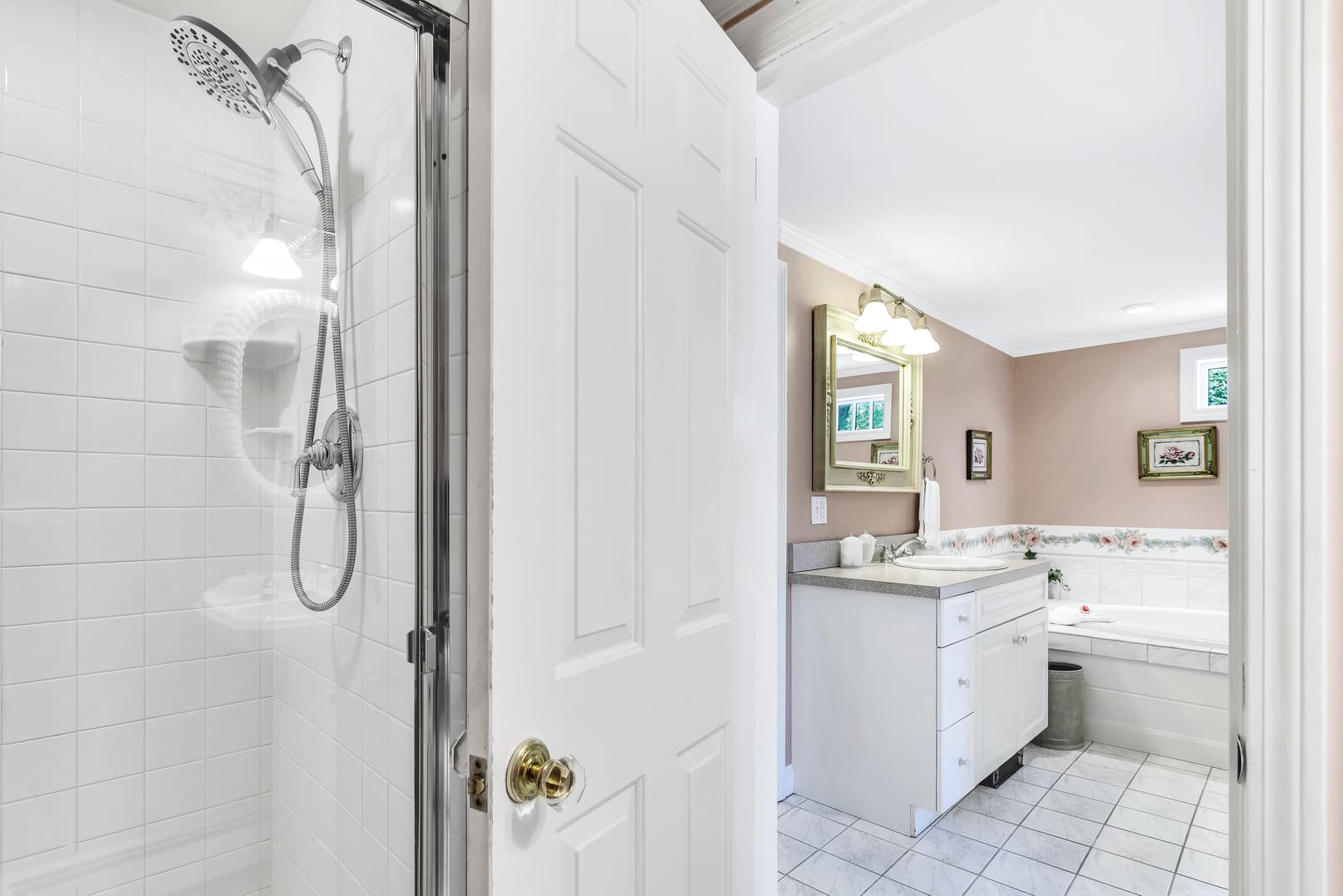 close up of gas fireplace, flatscreen TV and Mitsubishi A/C and heater unit above, wingback chair, side table with lamp, large windows with white blinds, floral window valences to coordinate with light green patterned wallpaper