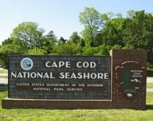 Sign for Cape Cod National Seashore, displaying park names and logos.