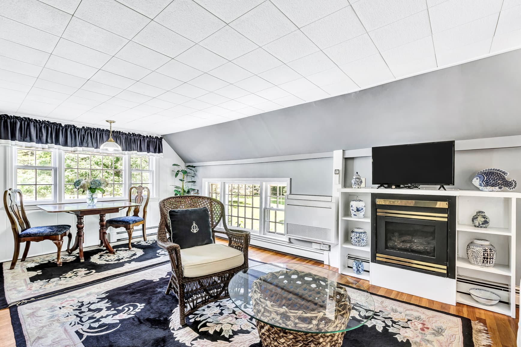 Bright, modern living room featuring a seating area, dining table, and a fireplace.