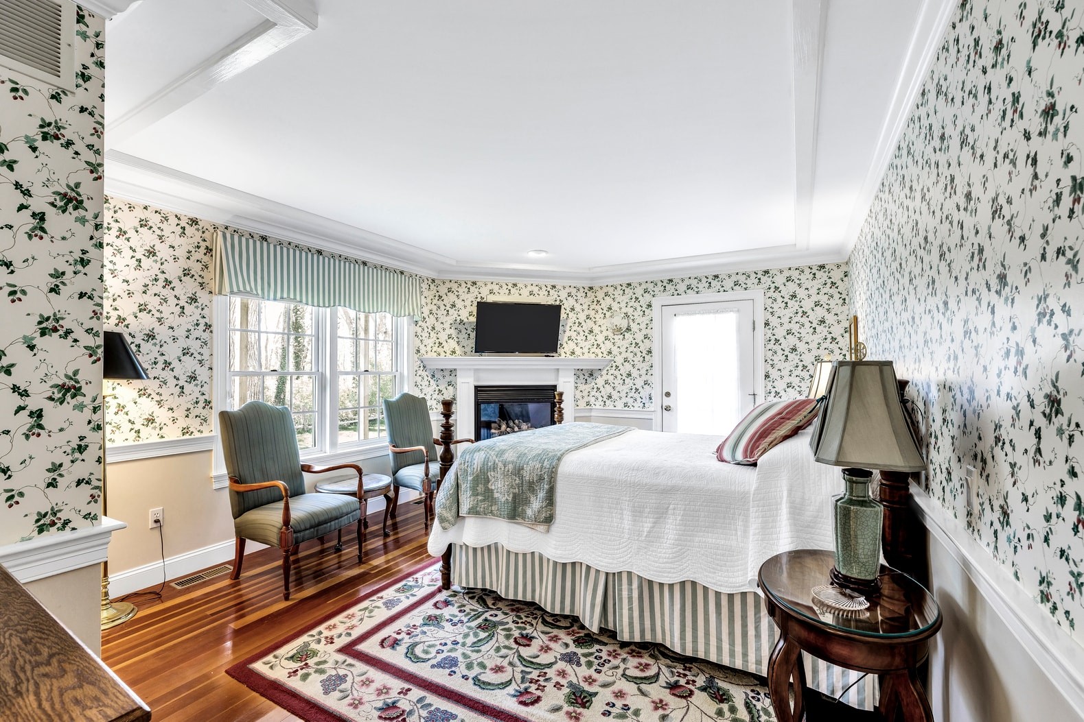 queen bed, fireplace, flatscreen streaming TV, sitting area, door to patio