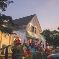 Photo of the white cottage Ice Cream Cafe at dusk.