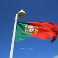 THE PORTUGUESE FLAG FLYING ON A FLAGPOLE.